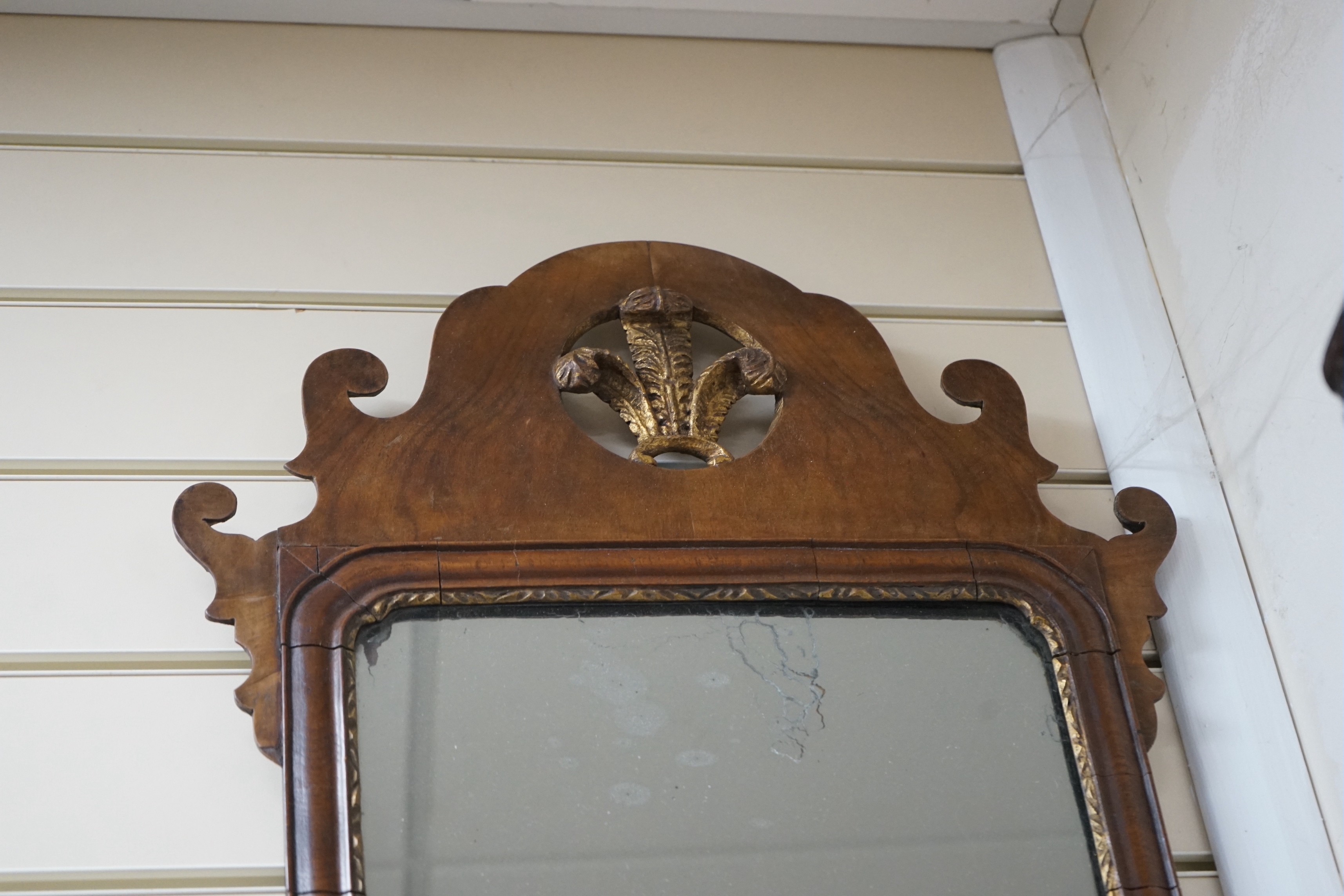 A George III style walnut and parcel gilt fret cut mirror, width 42cm, height 81cm